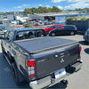 Black mitsubishi triton double cab with a textured soft tonneau cover for 2015-2023 models shown from the back side