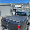 Black fabric soft tonneau cover on the back side of a mitsubishi triton 2015-2023 double cab pickup truck