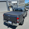 Dark gray mitsubishi triton double cab with black soft tonneau cover shown from the back side for 2024+ model