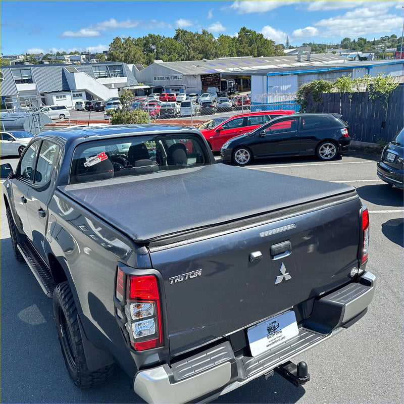 Back view of black mitsubishi triton 2024+ double cab with textured soft tonneau cover for pickup truck bed