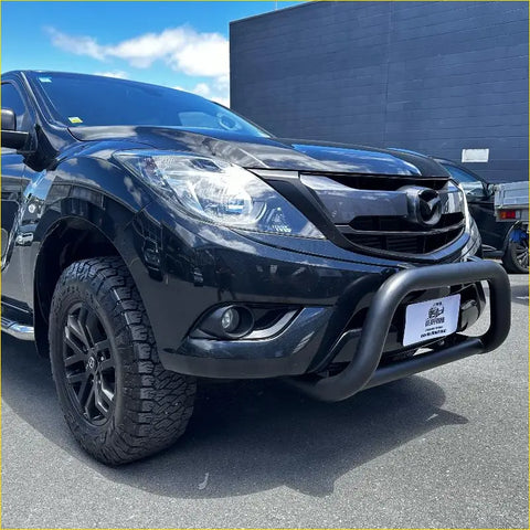 Black Mazda bt-50 with stainless steel matte medium size nudge bar and rugged off-road tires front view