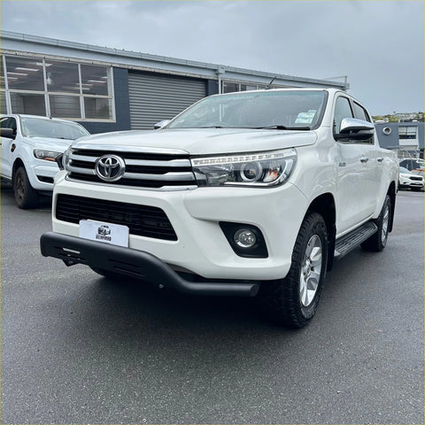 White toyota hilux pickup with chrome accents and black side steps showcasing stainless steel nudge bar black q1