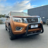 Bronze nissan navara pickup with a matte black stainless steel nudge bar and black front bumper guard