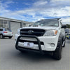 White Toyota Hilux pickup with matte black stainless steel nudge bar and black front bumper guard 2005-2015 model