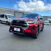 Red Toyota Hilux pickup with black front bumper guard featuring stainless steel nudge bar 2021-2025 medium model