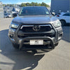 Gray toyota hilux 2021-2025 with stainless steel nudge bar and black front bumper guard with chrome accents