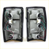 Black plastic tail light assemblies with chrome edge showing wiring and mounting for Mazda B2000 B2200 B2600 back side