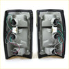 Black plastic tail light assemblies with internal wiring and mounting hardware for mazda bravo b2000 b2200 b2600 back side