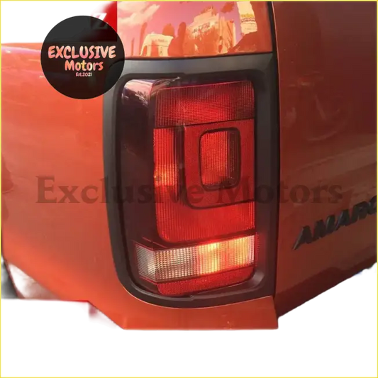 Backside of vw amarok tail light cover with black trim and rectangular red and amber illuminated sections