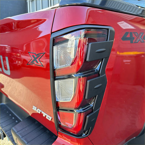 Red isuzu d-max 4x4 tail light back side with matte black taillight covers black trim and chrome accents 2024+