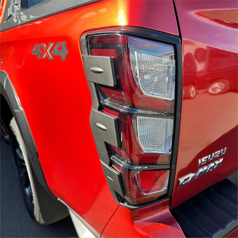 Back view of red isuzu d-max 4x4 truck tail light with chrome trim and layered led design matte black taillight cover