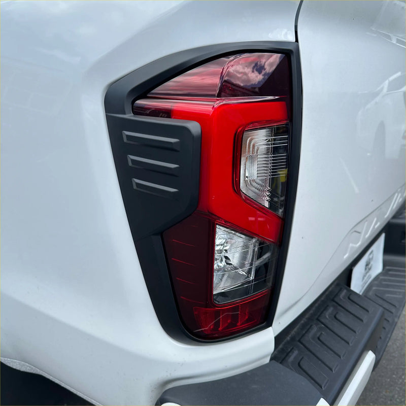 Backside of red and black angular taillight cover in matte black for nissan navara 2021 4x4 pickup truck