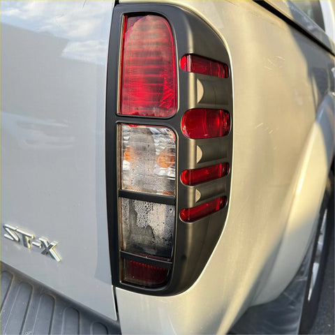 Black plastic tail light bezel with red and clear lenses on silver ford ranger st-x shown from the back side