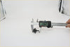 Black plastic carabiner being measured with digital caliper for window washer nozzle on nissan 720 navara sentra pathfinder datsun