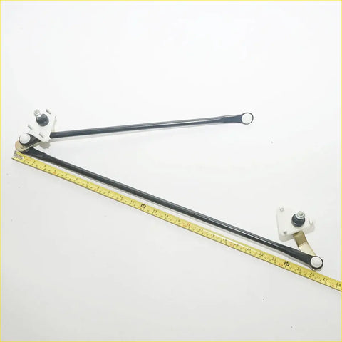 Black metal windshield wiper linkage arm with white plastic brackets and yellow measuring tape for nissan navara d21 back view
